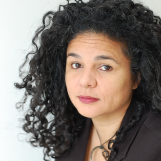 Headshot of author. Woman with curly dark hair.